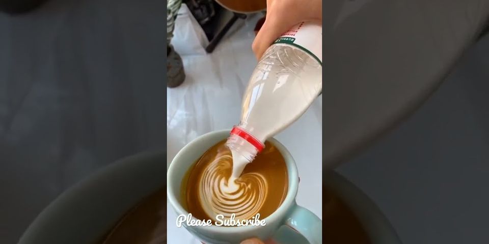 Espresso mit aufgeschäumter milch bedecken etwas kakaopulver